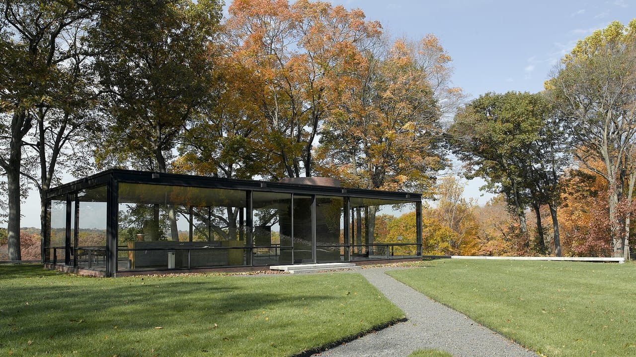 Philip Johnson's Glass House in New Canaan, Connecticut, a single glass room on a lawn surrounded by autumn trees