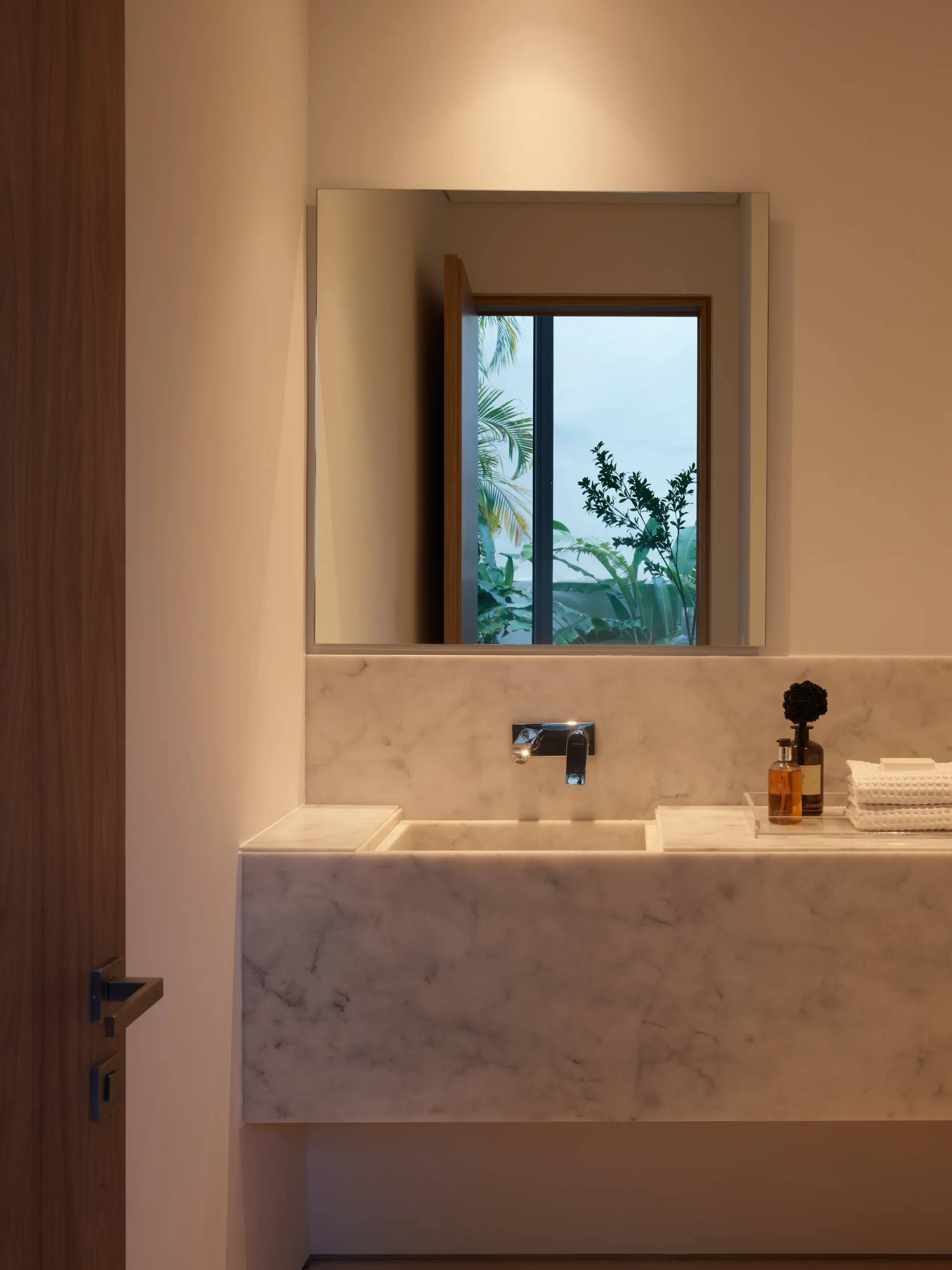 Spa bathroom with a stone vanity and framed mirror in the Onaway residence by LUXOM, Miami