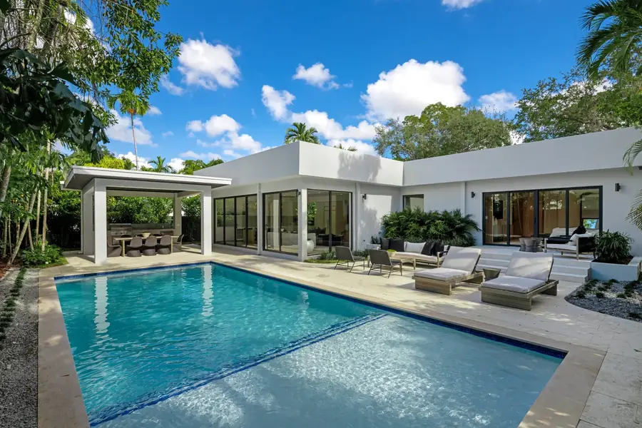 The finished Pinta Residence in Miami's Bay Heights, single storey L-shaped plan wrapping the pool and pergola, the same home shown in Luxom's empty lot to finished home reel